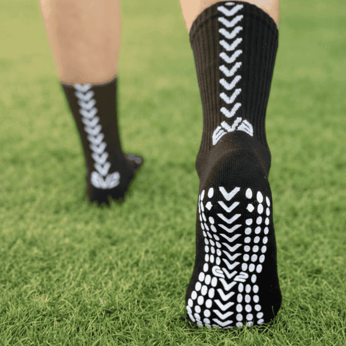 EV2 Black Grip Socks on grassy field pictured from the sole of the foot