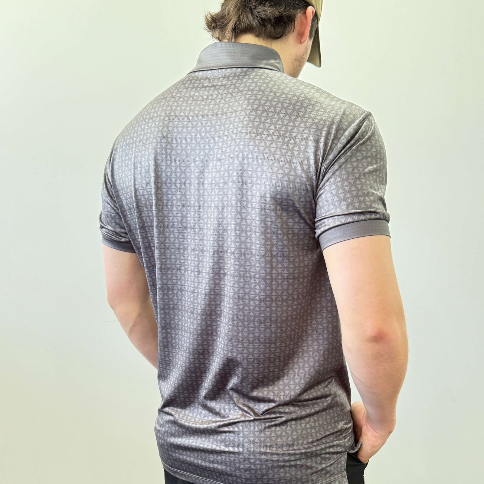 Person wearing a Charcoal and Grey EV2 Diamond patterned golf shirt and black golf shorts standing in front of a white background.
