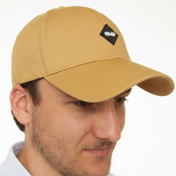 Man wearing a beige baseball cap with an EV2 logo on a white background